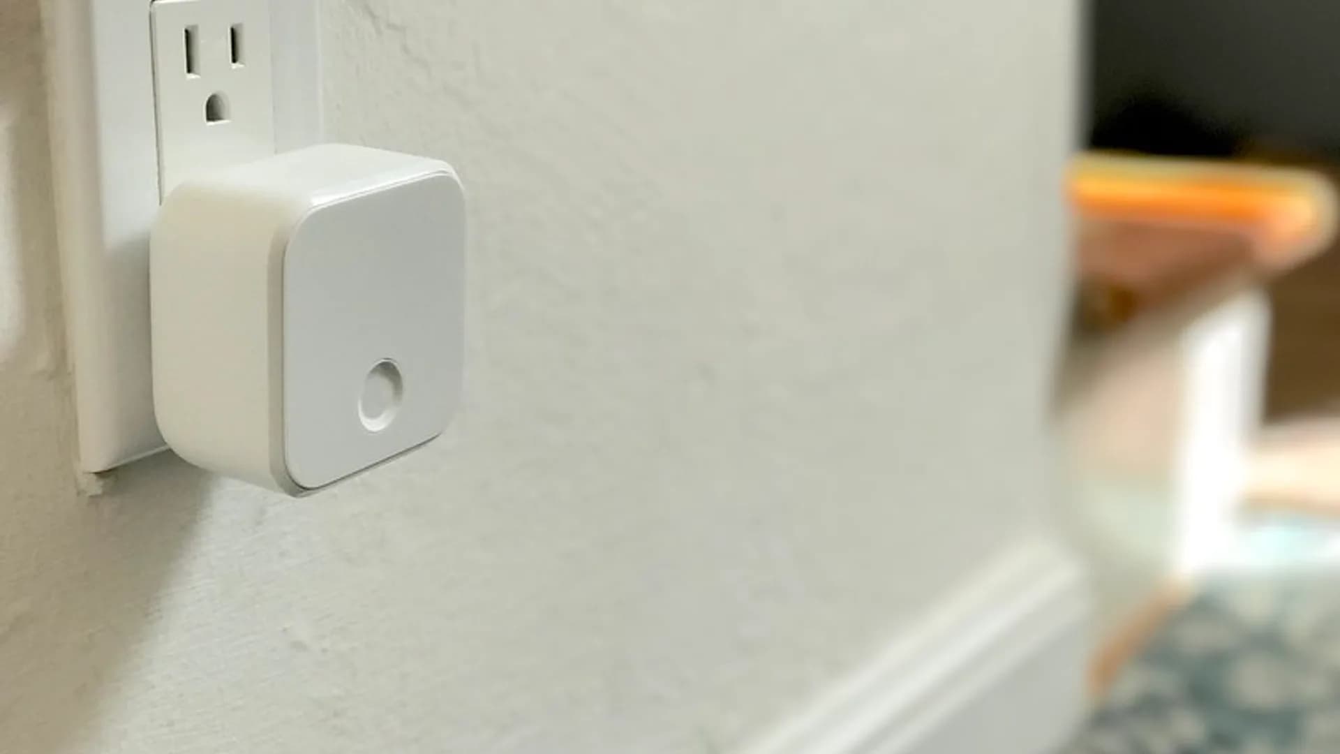 Cozy living room with a smart speaker, smart bulb lamp, and a phone app controlling smart home devices
