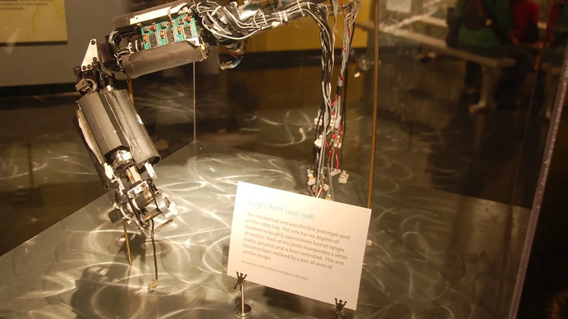A robotic arm working at a computer keyboard, illustrating autonomous AI agents carrying out multi-step digital tasks.
