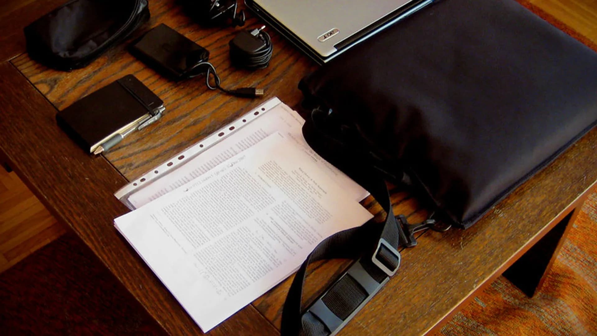 Person checking storage usage on a smartphone next to an open laptop on a wooden desk